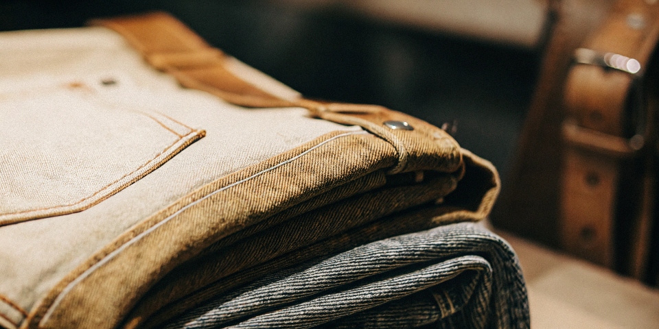 A close-up shot of a thick, 16oz selvedge denim fabric, highlighting its dense weave and rich texture.