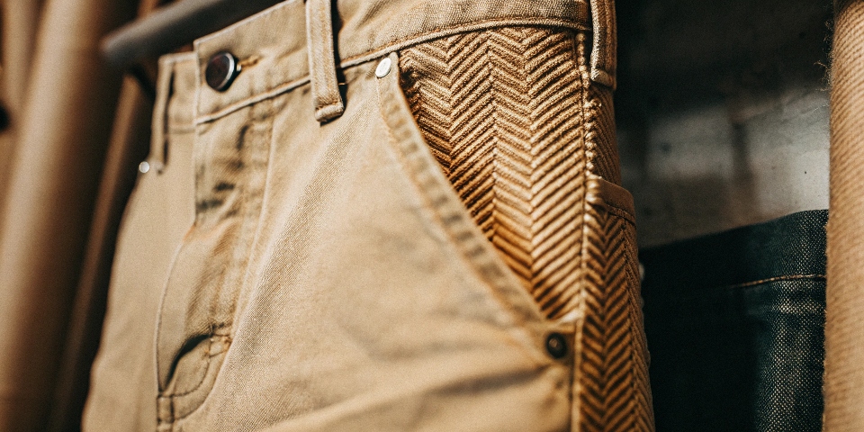 A macro shot of a bright red denim fabric, highlighting the diagonal twill weave.