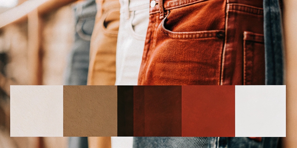 A color palette swatch with white, black, olive, and red next to a pair of medium-wash blue jeans.