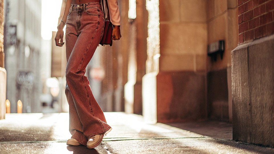 A stylish Gen Z individual confidently wearing loose, baggy jeans, contrasted with the memory of a tight skinny jean silhouette.