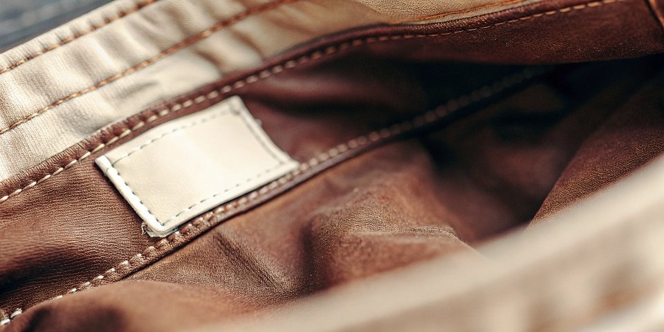 A close-up photo of an internal care tag on a pair of jeans, with the model number circled.