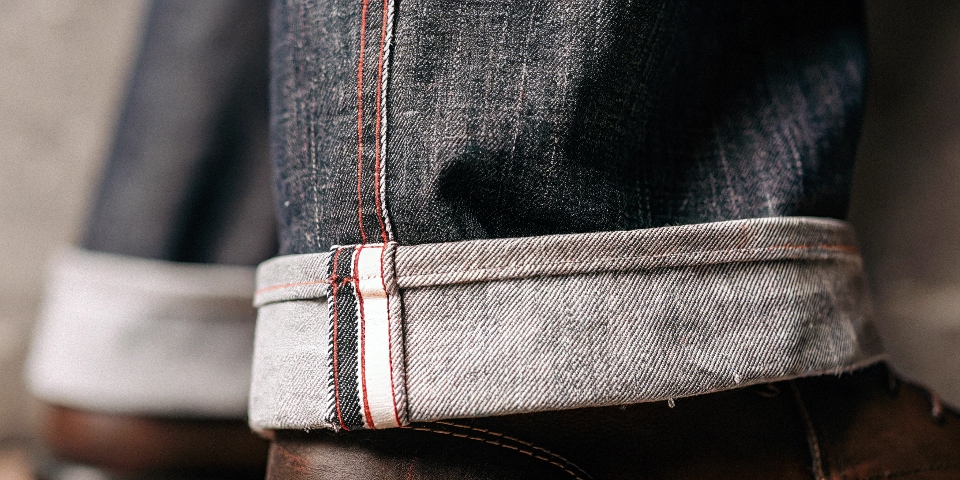 A detailed shot highlighting the iconic red-line selvedge edge on the cuff of a premium pair of jeans.