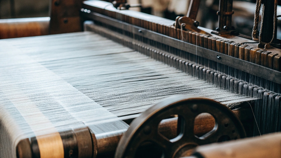 A photo of a traditional shuttle loom, highlighting its complex, mechanical nature compared to modern machinery.