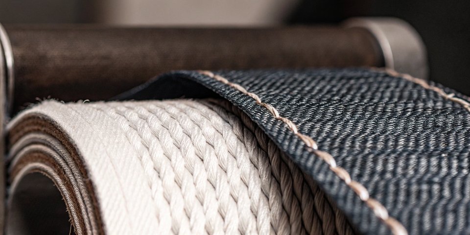 A macro close-up shot showing the distinct diagonal weave and texture of a blue denim fabric.
