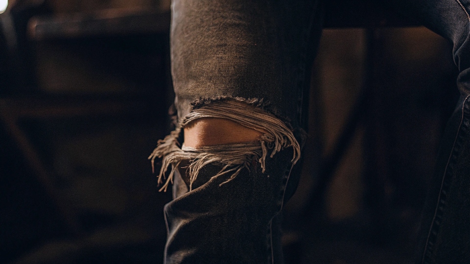 A close-up on the knee rip of a pair of jeans.