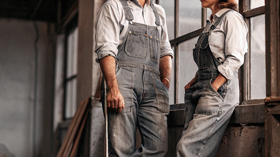 A vintage black and white photo of workers wearing classic blue denim workwear.