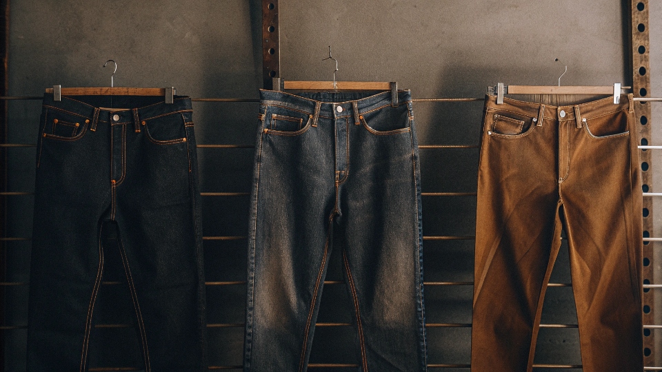 A height chart next to three pairs of jeans with different inseams (30, 32, 34) to show the difference in length.