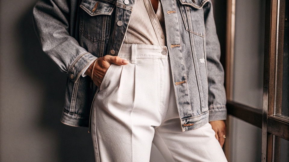 A stylish and confident person over 50 wearing a classic blue denim jacket with elegant trousers.