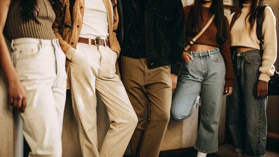 A group of young people wearing a variety of different jean styles, from baggy to slim-fit.