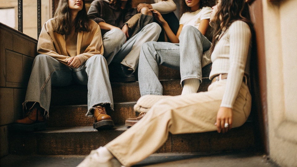 A group of young people in baggy jeans, showcasing different washes and styles inspired by 90s skater culture.