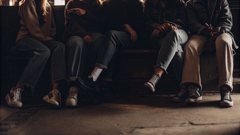 A group of young people in baggy jeans, reflecting 90s skate and street style.