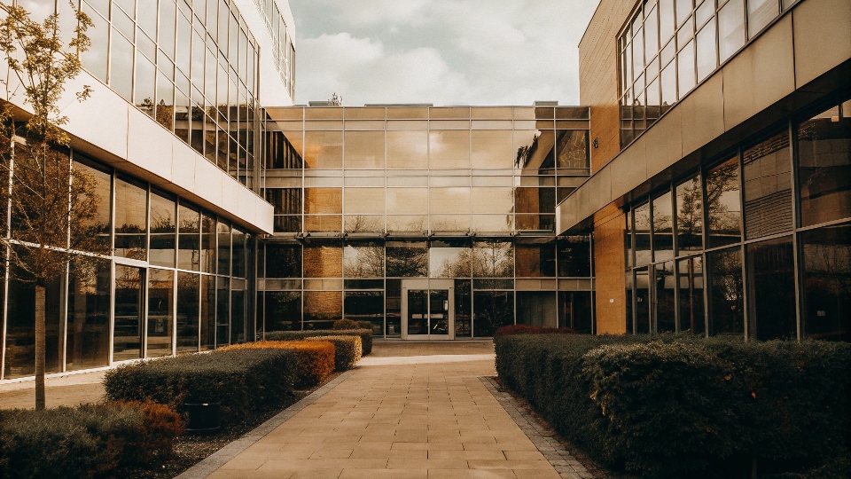 A modern, glass-facade office building with a sign for a major apparel group.