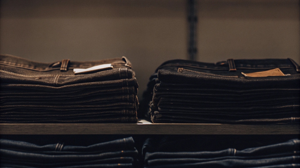 A pair of Newport brand jeans on a store shelf, clearly showing the price tag.