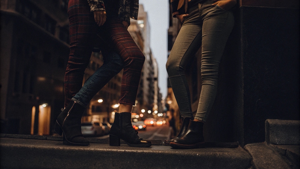 A classic 2010s street style photo with people in colorful skinny jeans and ankle boots.