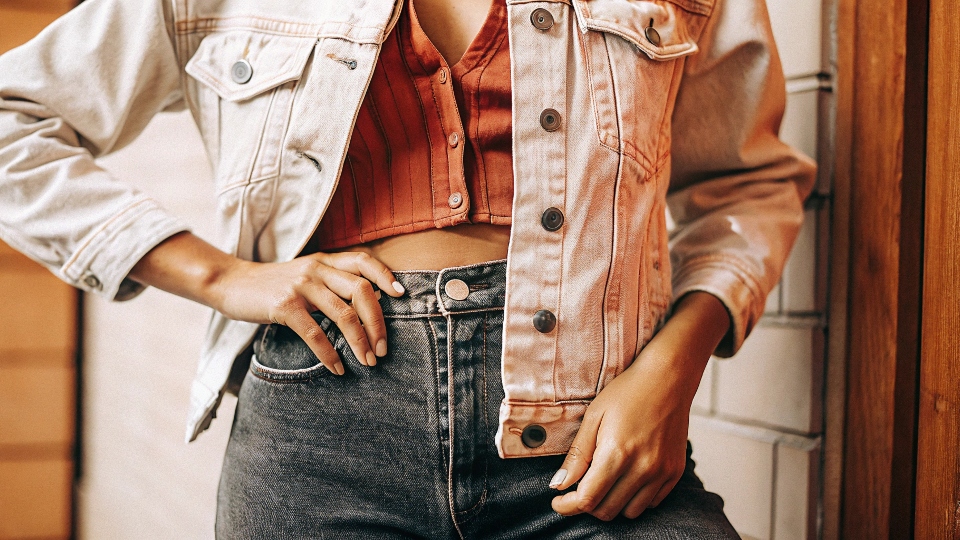 A stylish person confidently wearing a light-wash denim jacket with dark, raw denim jeans.