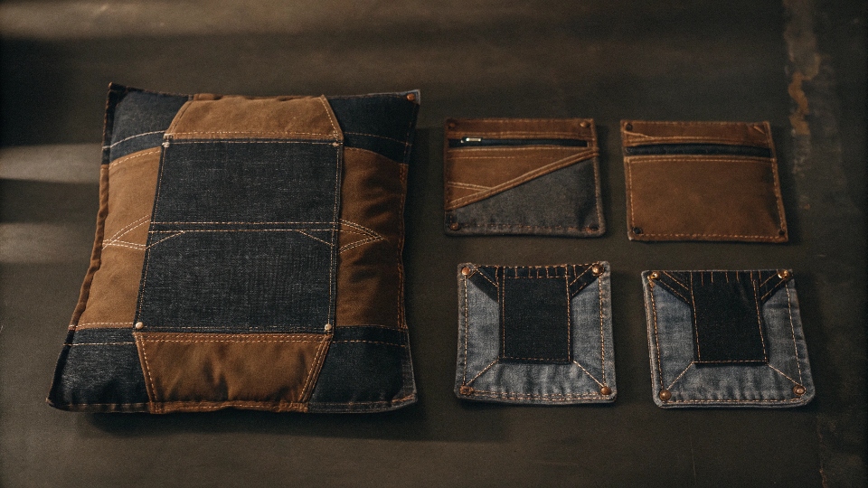 A collection of creative items made from old jeans, such as a pillow cover, coasters from seams, and a small pouch.
