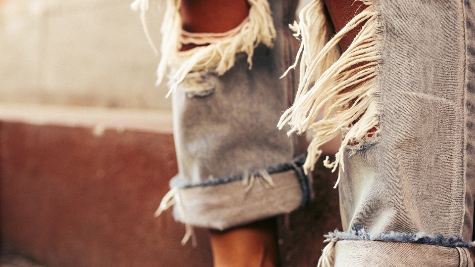 A close-up of a perfectly frayed jean hem after it has been through the washing machine.