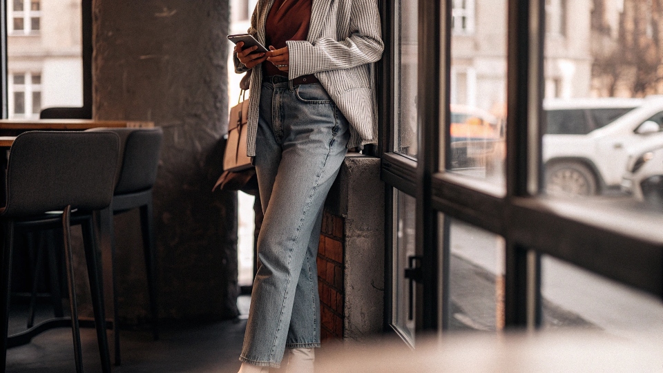 A person looking fashionable in well-styled oversized jeans with a fitted top and blazer.