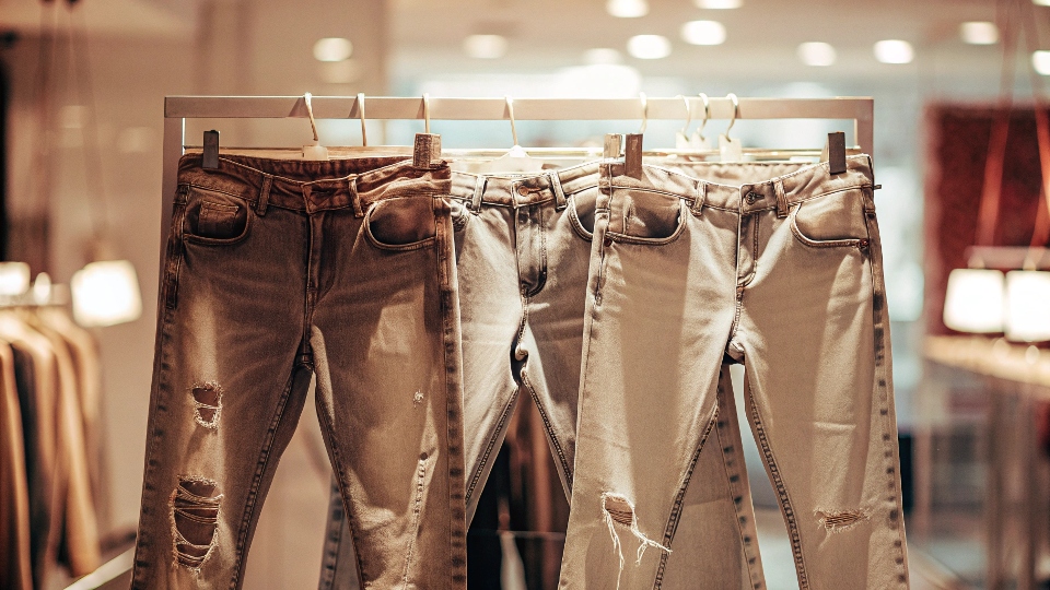 A display of trendy, heavily distressed, and lightweight jeans in a fast-fashion retail store.
