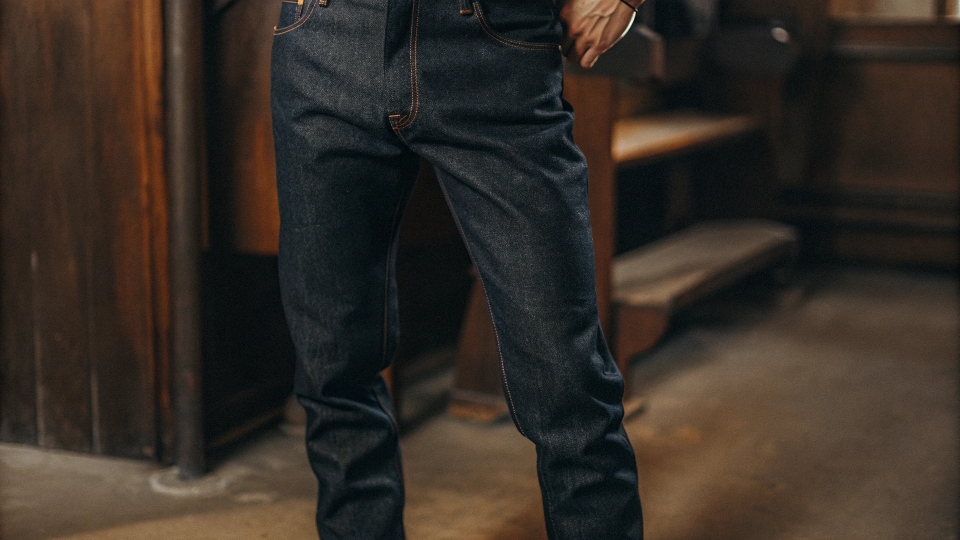 A close-up of a person wearing perfect business casual jeans: dark, clean, and well-fitting.
