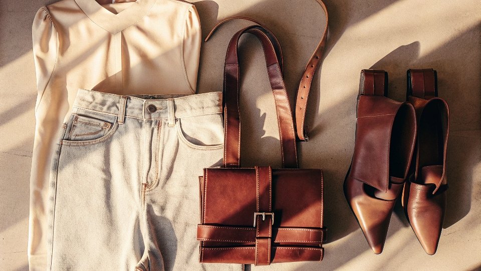 A chic outfit: high-waisted baggy jeans with a tucked-in top, stylish belt, and pointed shoes.