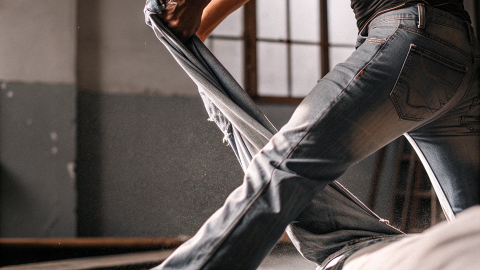 A person wearing damp jeans and doing lunges to stretch the fabric.