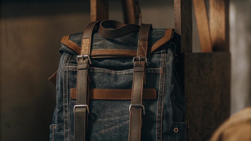 Denim backpack made from old jeans with visible back pockets and belt detail.
