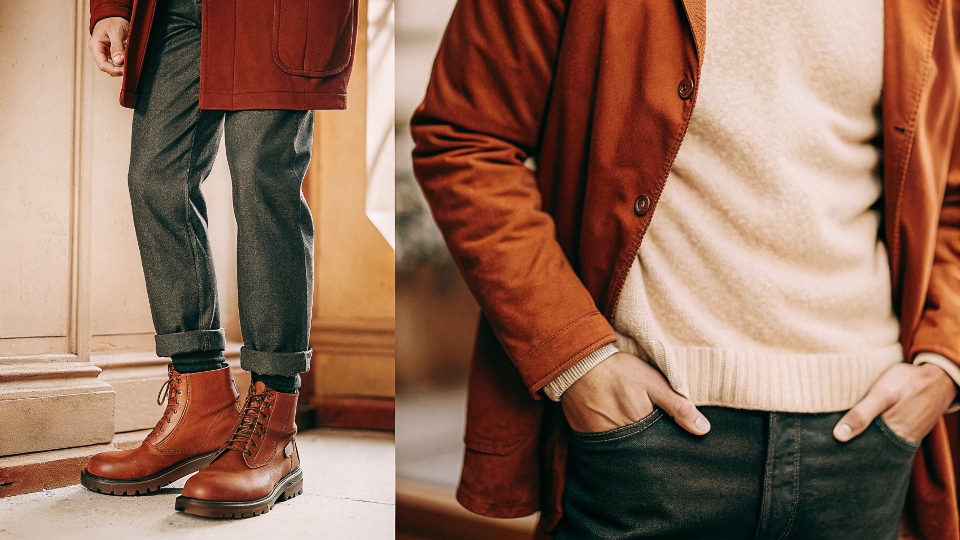 A man styled for fall, wearing dark baggy jeans with a cozy sweater, a stylish jacket, and sturdy boots.