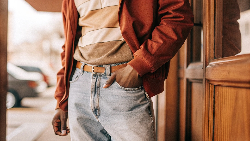 A skinny guy confidently wearing well-proportioned baggy jeans and a layered top.