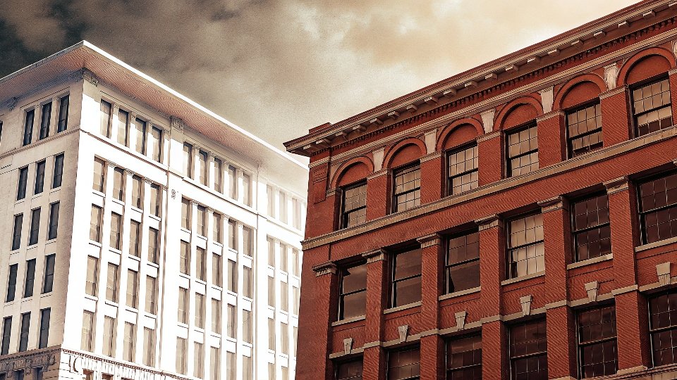 A vintage black-and-white photo of the original H.D. Lee Mercantile Company building, contrasted with a modern office building for Kontoor Brands.