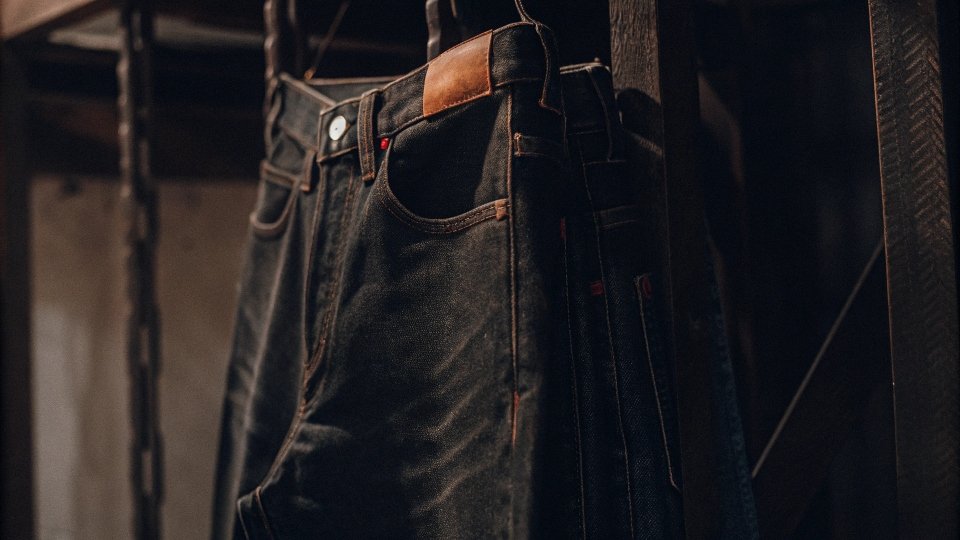 A classic pair of Levi's 501 jeans hanging with the iconic red tab and leather patch visible.