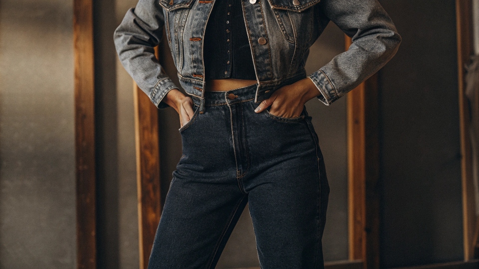 A stylish person confidently wearing a light wash denim jacket with dark wash indigo jeans.