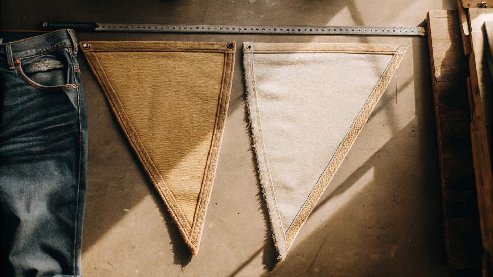 A flat lay showing a pair of jeans next to the two triangular fabric panels needed, with a ruler to show scale.