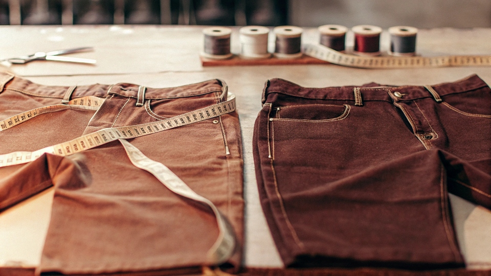 Tailoring and Altering Iconic Levi's Jeans A pair of classic Levi's 501s on a tailor's table, getting measured for a hem alteration