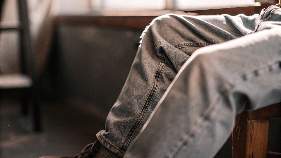 A close-up shot focusing on the excess fabric in the thigh and seat area of a pair of baggy jeans. 