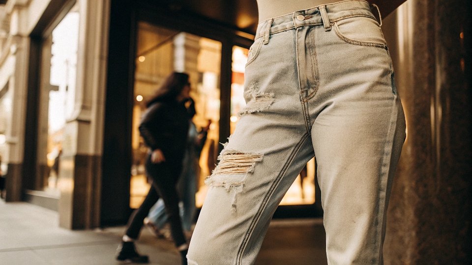 Modern Distressed Denim in 2025 A street-style photo of someone wearing lightly distressed straight-leg jeans