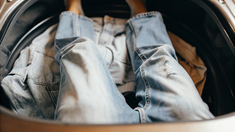 Jeans tumbling in a hot dryer