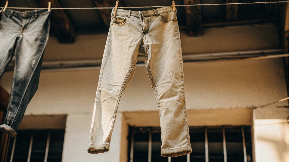A pair of jeans being hung on a clothesline to air dry
