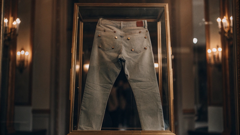 A photo of an extremely rare pair of vintage Levi's displayed in a museum or auction house setting
