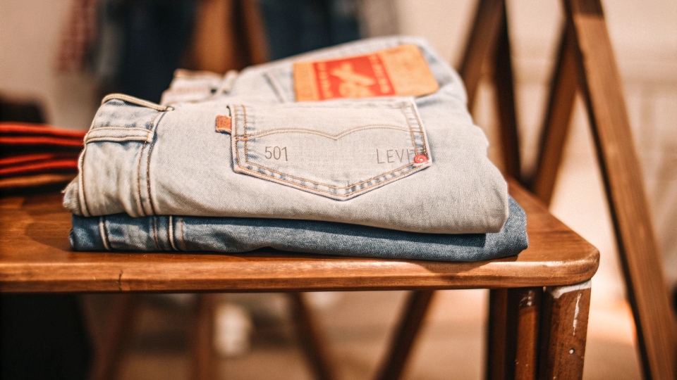 A classic pair of Levi's 501 jeans folded neatly on a wooden table