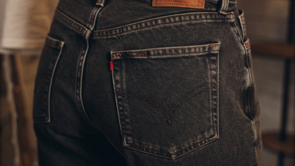 A classic pair of Levi's 501 jeans with the red tab prominently displayed on the back pocket