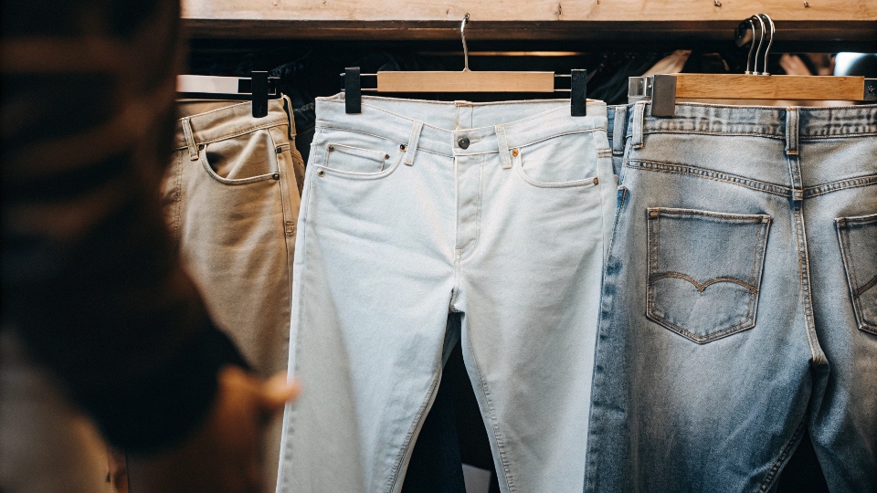 A consumer looking at Nike jeans on one side, and jeans from an authentic heritage denim brand on the other