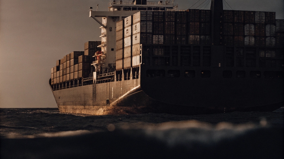 A large cargo ship with shipping containers, illustrating the long journey clothes take to reach stores.