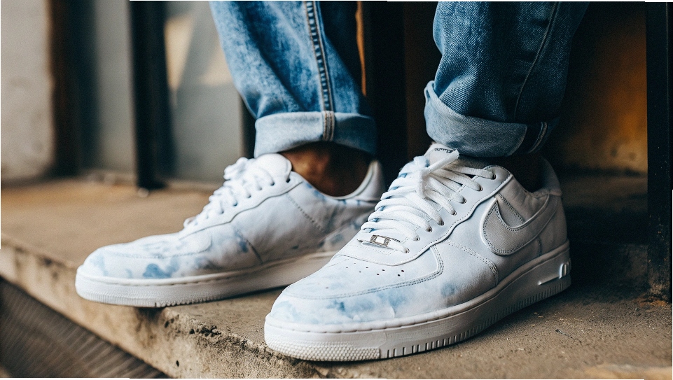 A person's white sneakers stained blue from the indigo dye bleeding off new raw denim jeans
