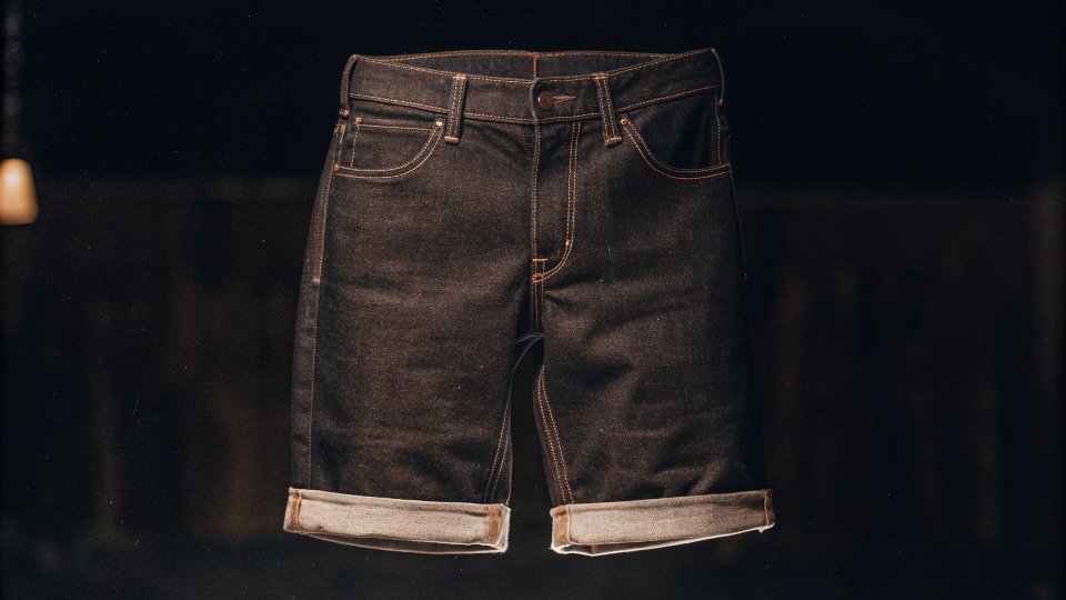 A pair of classic blue jean shorts on a white background