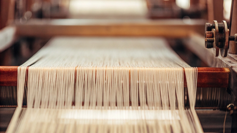 A vintage shuttle loom in action, weaving a narrow bolt of selvedge denim