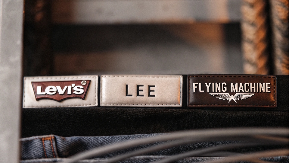 A collage of logos from popular denim brands available in India like Levi's, Lee, and Flying Machine