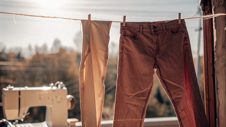 A pair of jeans hanging on a clothesline, drying in the fresh air and sunlight