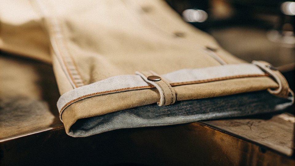 A close-up of a selvedge ID line on the outseam of a cuffed pair of high-quality jeans