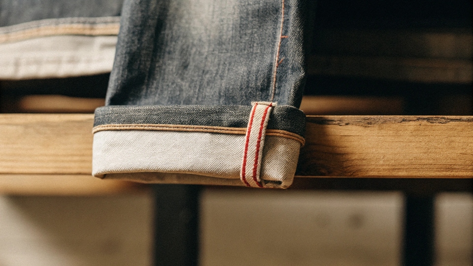 A close-up shot showing the red-line selvedge ID on the cuff of a pair of Uniqlo jeans